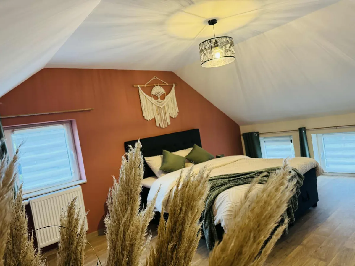 Chambre boho au mur terracotta avec lit double, gîte romantique à Couvin